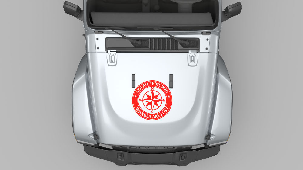 Red wanderers compass circle hood decal displayed on white Jeep Wrangler JL hood, bold travel-inspired vinyl graphic.