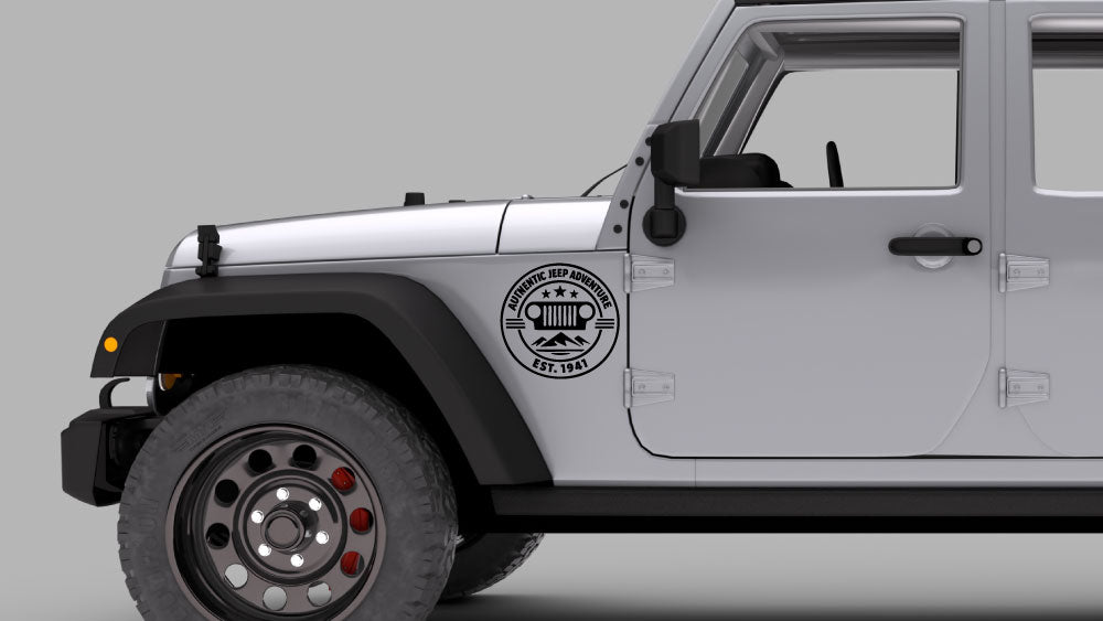 Silver Jeep Wrangler JK with black “Authentic Jeep Adventure” badge fender decal near front wheel