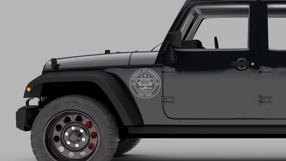 Black Jeep Wrangler JK with gray “Authentic Jeep Adventure” badge fender decal near front wheel