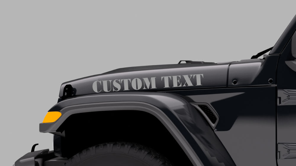 Custom text hood side decal installed on gray Jeep Wrangler JL showing personalized lettering graphic on the driver side hood panel